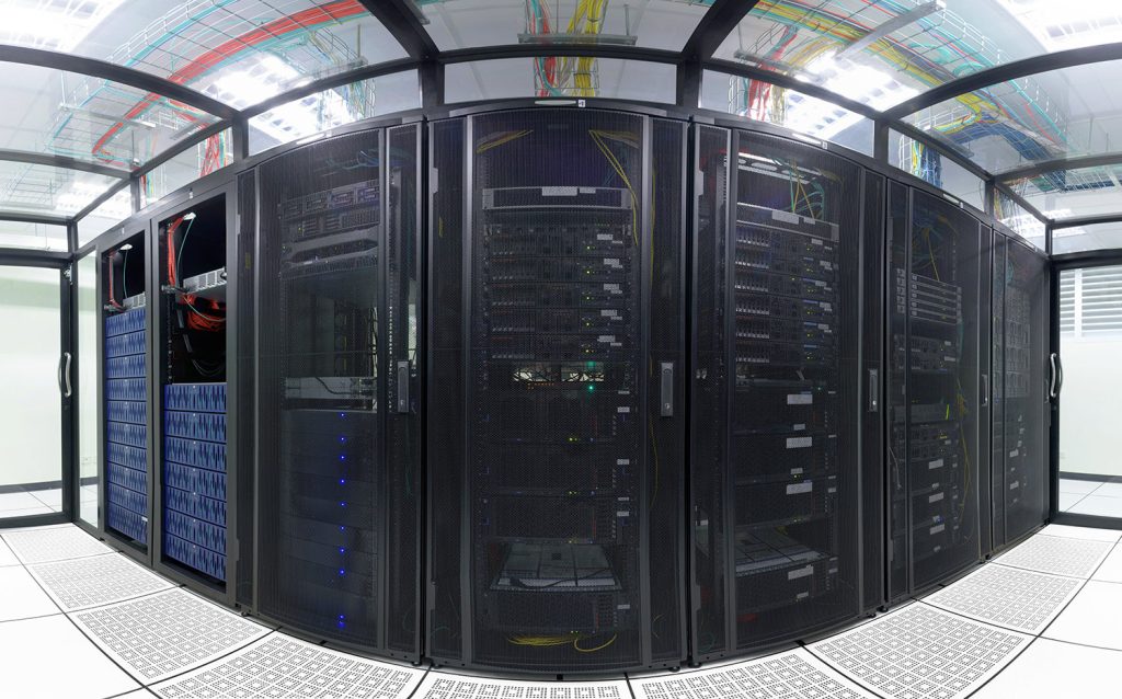 A sleek data center filled with black server racks, showcasing high-tech equipment and organized cabling above.
