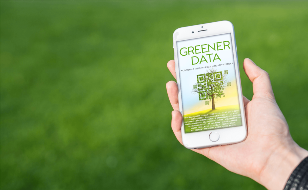 A hand holds a smartphone displaying a poster about 'Greener Data' with a QR code, against a green grassy background.